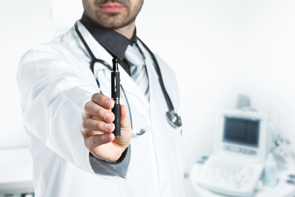 A scientist dressed in a white lab coat holds up an electronic cigarette.