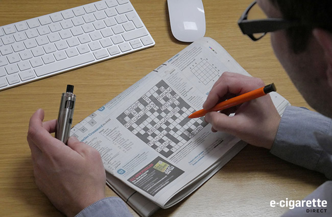 Man Vaping while attempting a Crossword