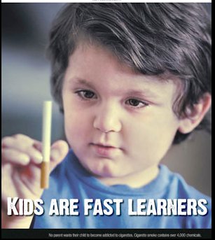 Kids are fast learners: A child holds a cigarette in his hand. 