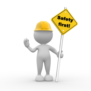 Cartoon man in hard yellow hat holding safety first sign. 