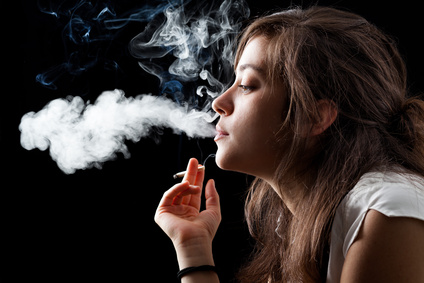 A woman exhales a cloud of smoke.