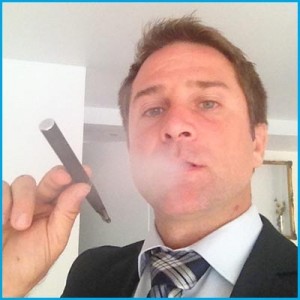 Headshot of Stephen Vlachos with e-cigar in hand. 