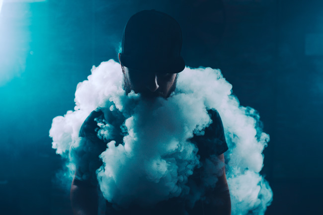 A man is enveloped in a cloud of vapour.