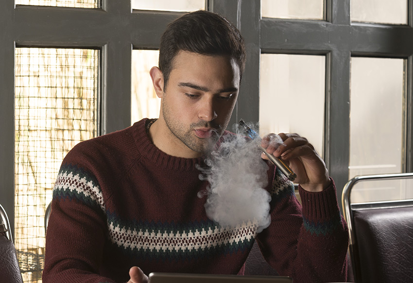 Inhaling from a pen-style e-cig.  