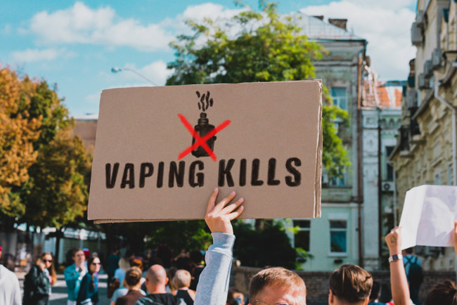 A protest with someone holding a 'vaping kills' placard