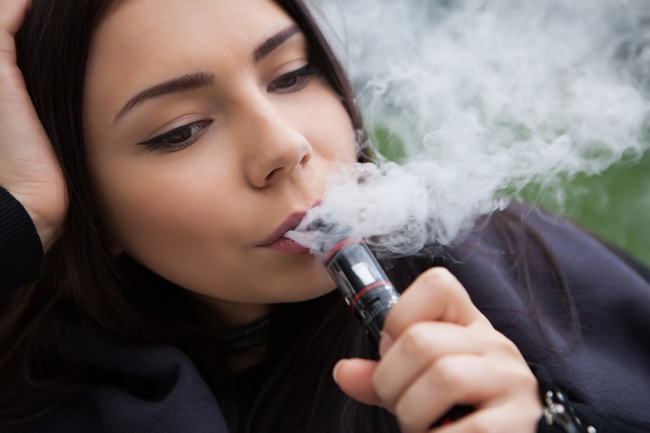 Young woman inhaling on a vape device