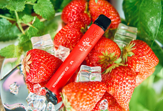 Image of a Strawberry Elf Bar disposable vape device amongst a pile of strawberries and ice cubes