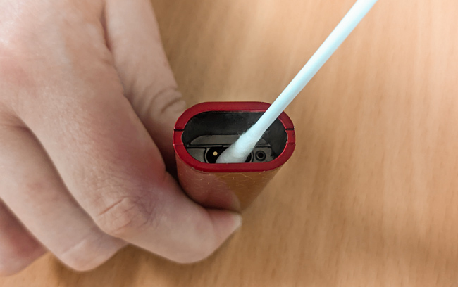A pod device being cleaned with a cotton bud.