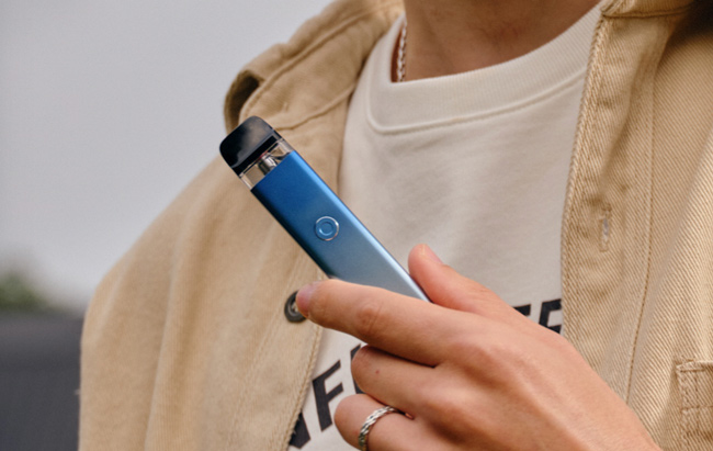 Man holding a light blue Xros device. 