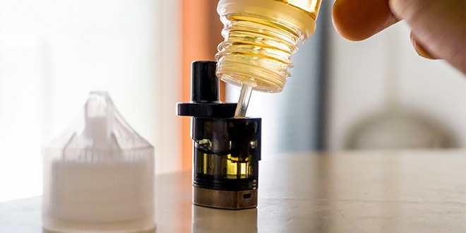 Image of a vape tank being filled with vape juice